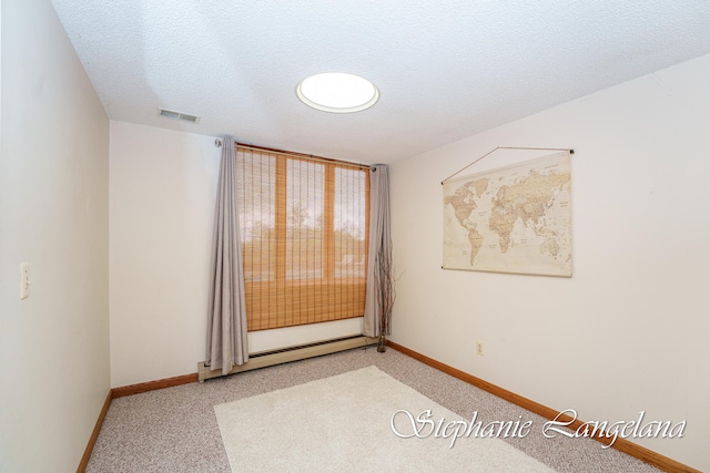 unfurnished room with a textured ceiling and baseboard heating