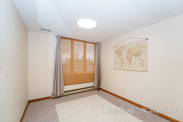 7300 Packer Dr NE, Belmont, MI 49306 - spare room featuring a baseboard heating unit, light colored carpet, and baseboards