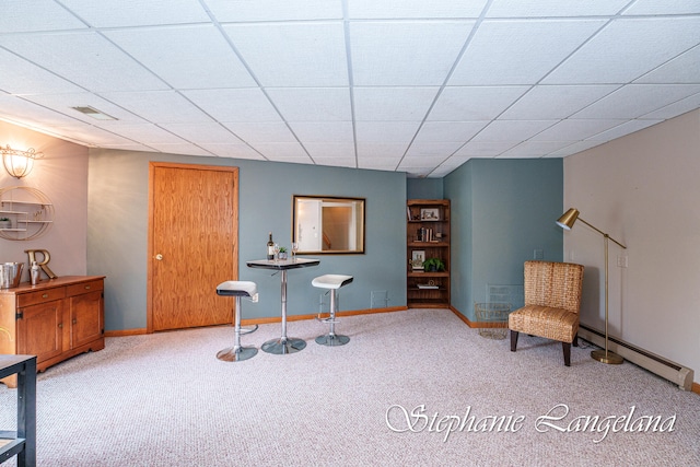 sitting room with carpet, a paneled ceiling, and a baseboard heating unit