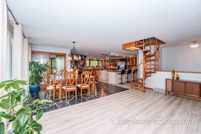 7300 Packer Dr NE, Belmont, MI 49306 - dining space with wood finished floors, stairway, and a chandelier