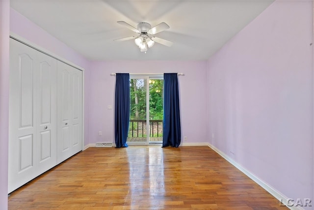 unfurnished bedroom featuring ceiling fan, access to exterior, light wood-type flooring, and a closet