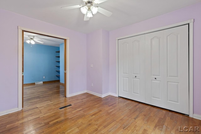 unfurnished bedroom featuring ceiling fan, light hardwood / wood-style floors, and a closet