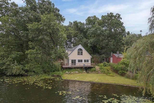 rear view of house featuring a deck with water view and a yard