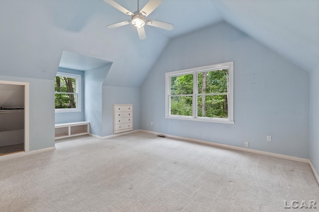 additional living space with ceiling fan, light colored carpet, and lofted ceiling