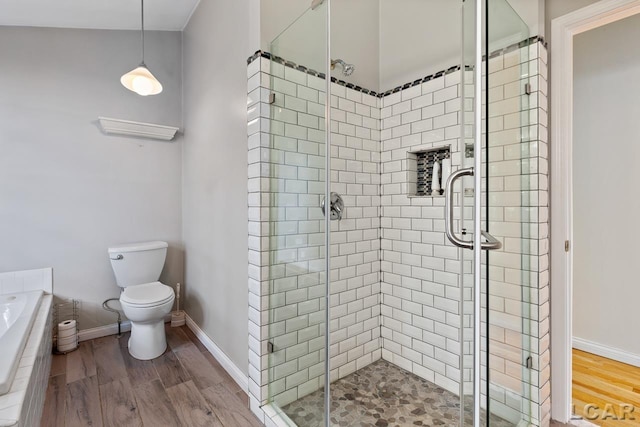 bathroom with walk in shower, toilet, and hardwood / wood-style flooring