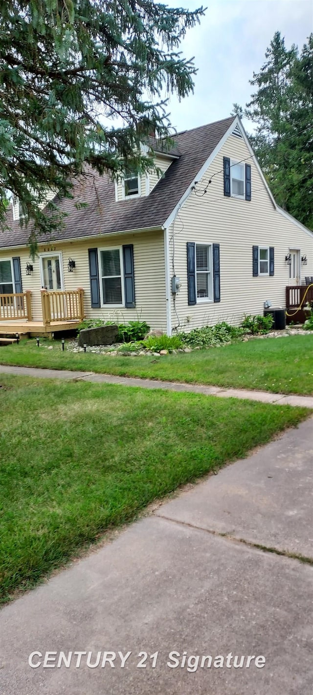 view of front of house with a deck and a front lawn