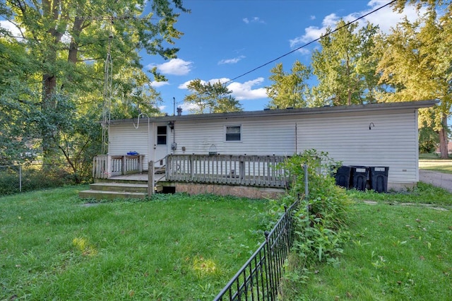 back of house featuring a lawn and a wooden deck