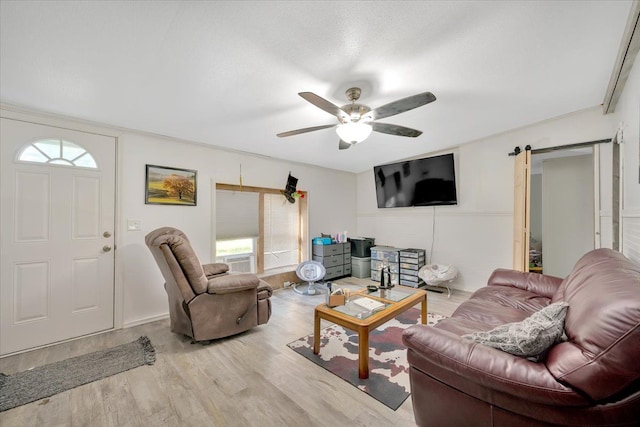 living room featuring light hardwood / wood-style floors, crown molding, ceiling fan, and a healthy amount of sunlight