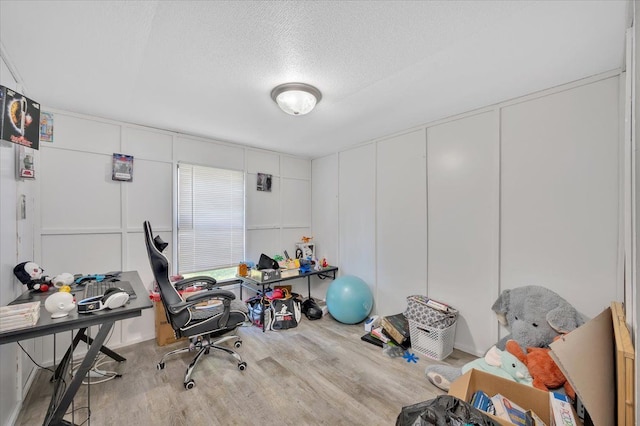 interior space with a textured ceiling and light hardwood / wood-style flooring