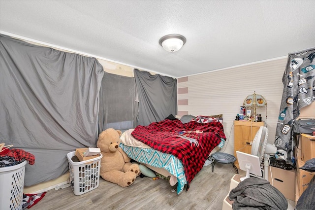 bedroom with a textured ceiling and light wood-type flooring