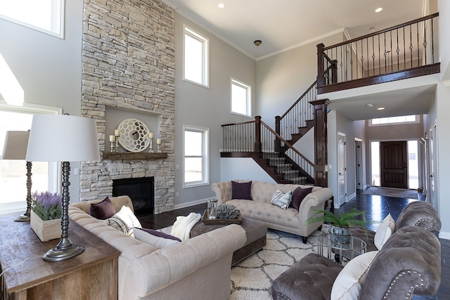 living room featuring a high ceiling, hardwood / wood-style flooring, plenty of natural light, and crown molding