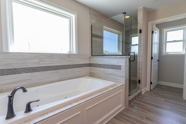 bathroom featuring wood-type flooring and separate shower and tub