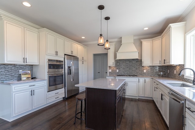 kitchen with a center island, appliances with stainless steel finishes, dark hardwood / wood-style floors, and sink