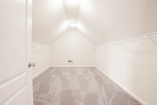 spacious closet with carpet flooring and vaulted ceiling