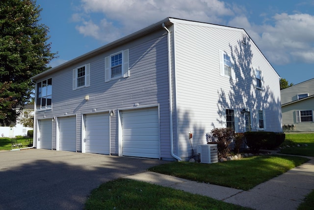 view of property exterior featuring central AC unit and a garage