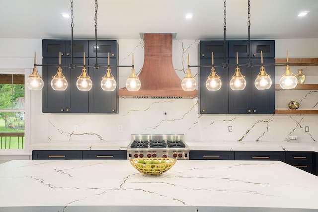 kitchen with decorative backsplash, light stone counters, hanging light fixtures, and exhaust hood