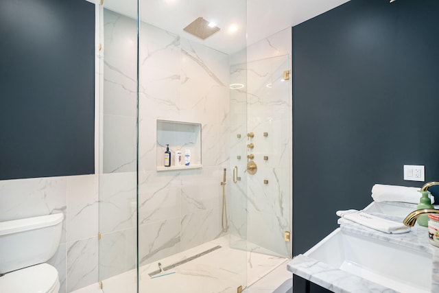 bathroom featuring tiled shower, vanity, toilet, and tile walls