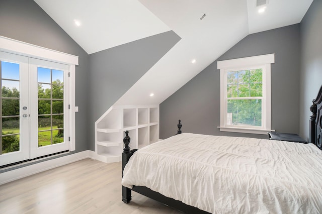 bedroom with vaulted ceiling, access to exterior, light wood-type flooring, and multiple windows