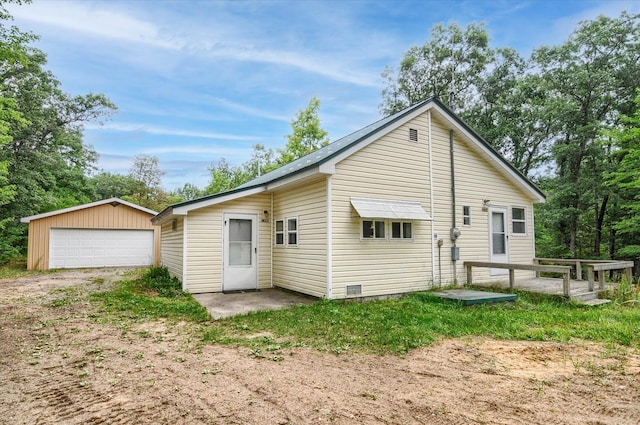 rear view of house with an outbuilding, a garage, and a deck