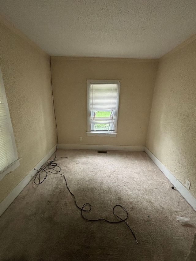 unfurnished room featuring carpet flooring and a textured ceiling