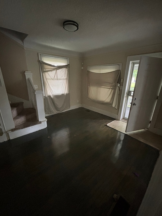 entryway with a textured ceiling and dark hardwood / wood-style floors