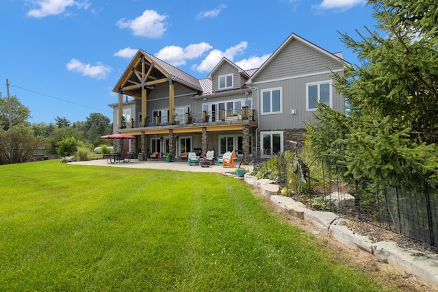 back of house with a yard and a patio