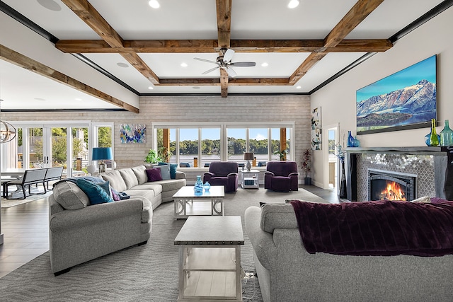 living room with ceiling fan, a healthy amount of sunlight, and beam ceiling