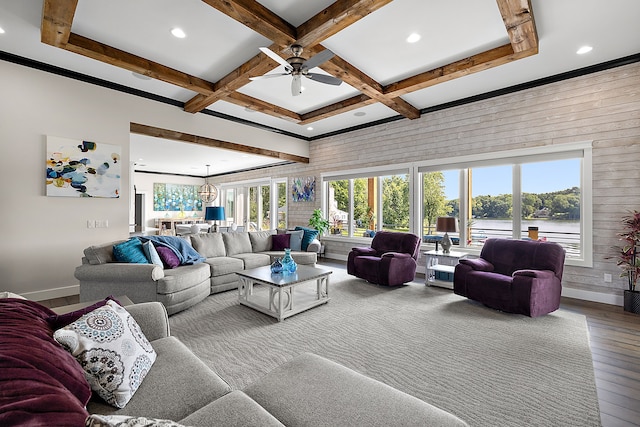 living room featuring coffered ceiling, ceiling fan with notable chandelier, wood-type flooring, beam ceiling, and a water view