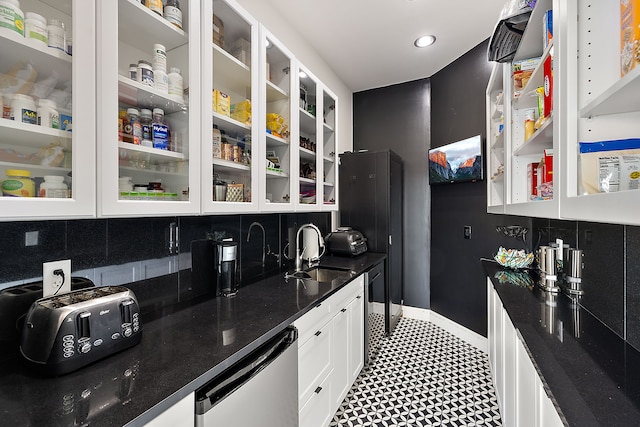 kitchen with tasteful backsplash, sink, and white cabinets