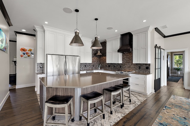 kitchen featuring a center island, custom range hood, dark wood-type flooring, and appliances with stainless steel finishes