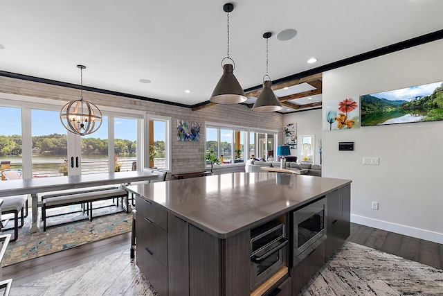 kitchen featuring wood-type flooring, stainless steel appliances, a kitchen island, and plenty of natural light