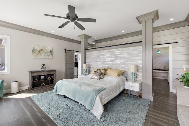 bedroom with ceiling fan, dark wood-type flooring, a barn door, decorative columns, and crown molding