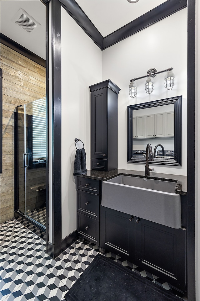 bathroom with vanity, crown molding, and wood walls