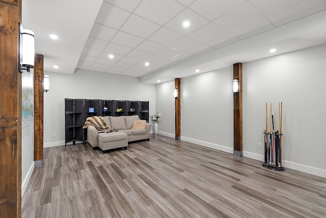 living room featuring a drop ceiling and light wood-type flooring