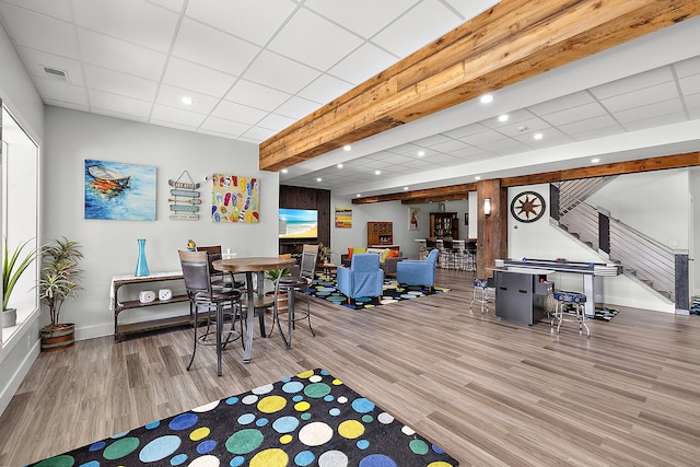 recreation room with a drop ceiling and hardwood / wood-style flooring