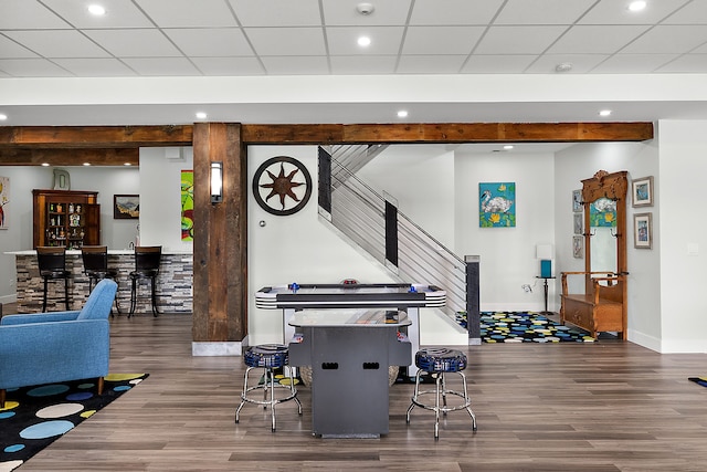 playroom featuring a paneled ceiling and dark wood-type flooring