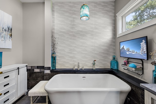 bathroom with tile patterned floors, vanity, a bath, and tile walls