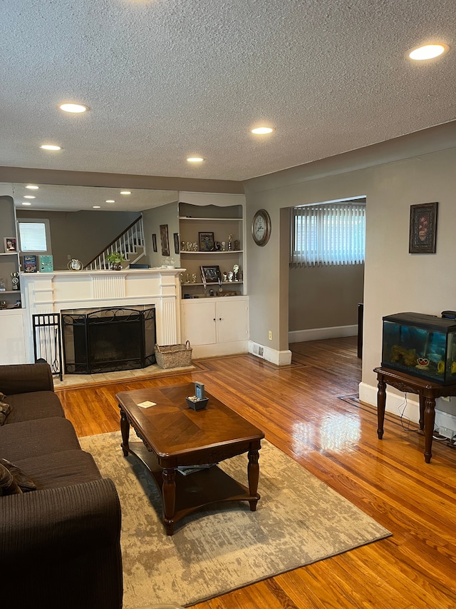 living room featuring a textured ceiling and light hardwood / wood-style flooring