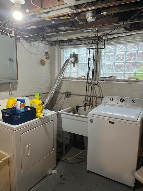 clothes washing area featuring electric panel and separate washer and dryer