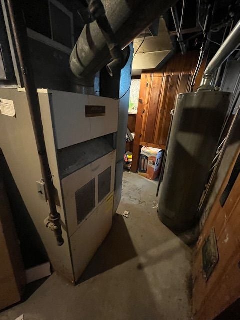 utility room featuring heating unit and water heater