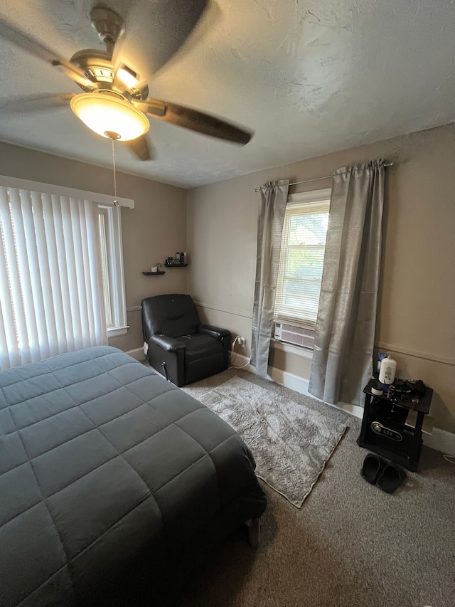 bedroom featuring cooling unit, ceiling fan, carpet, and a textured ceiling