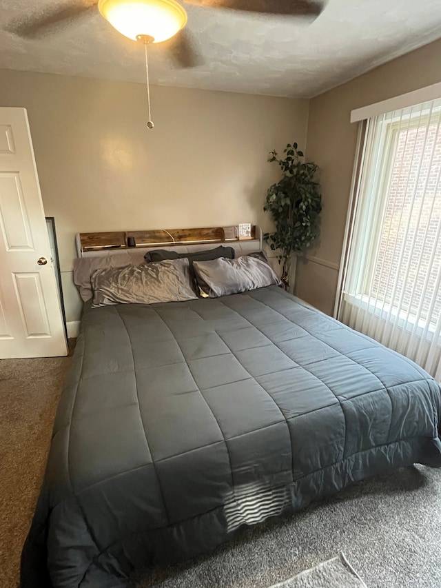 carpeted bedroom with a textured ceiling and ceiling fan