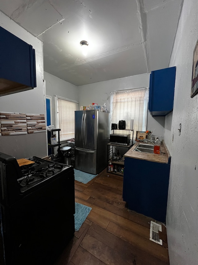 kitchen featuring sink, electric range, stainless steel fridge, blue cabinetry, and dark hardwood / wood-style flooring