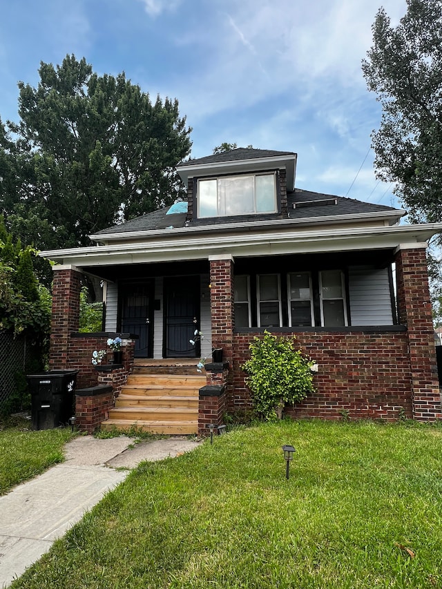 view of front of home with covered porch and a front yard