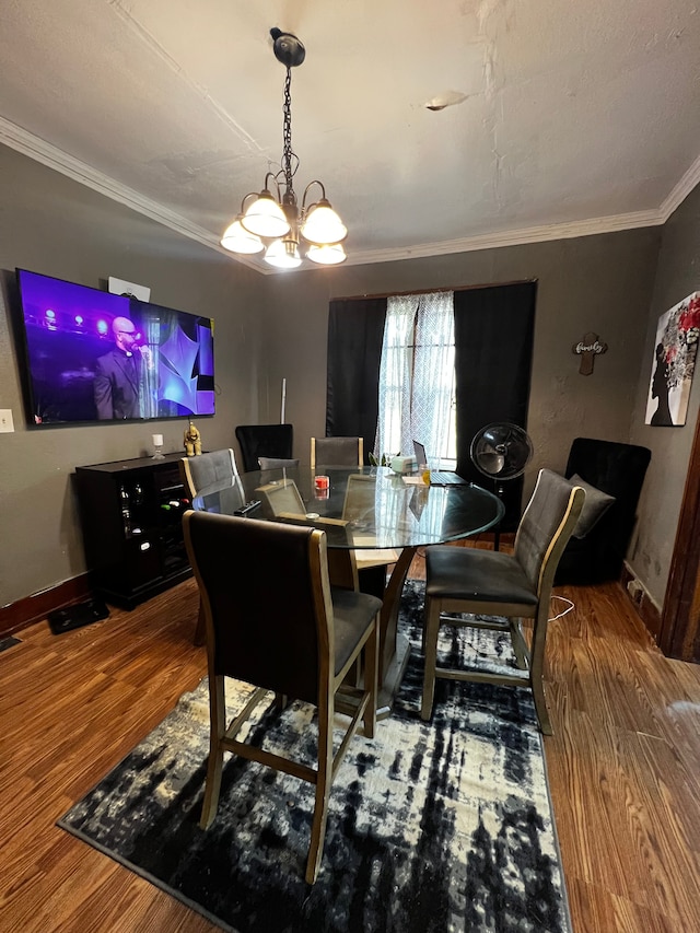 dining room with hardwood / wood-style floors, a chandelier, and ornamental molding