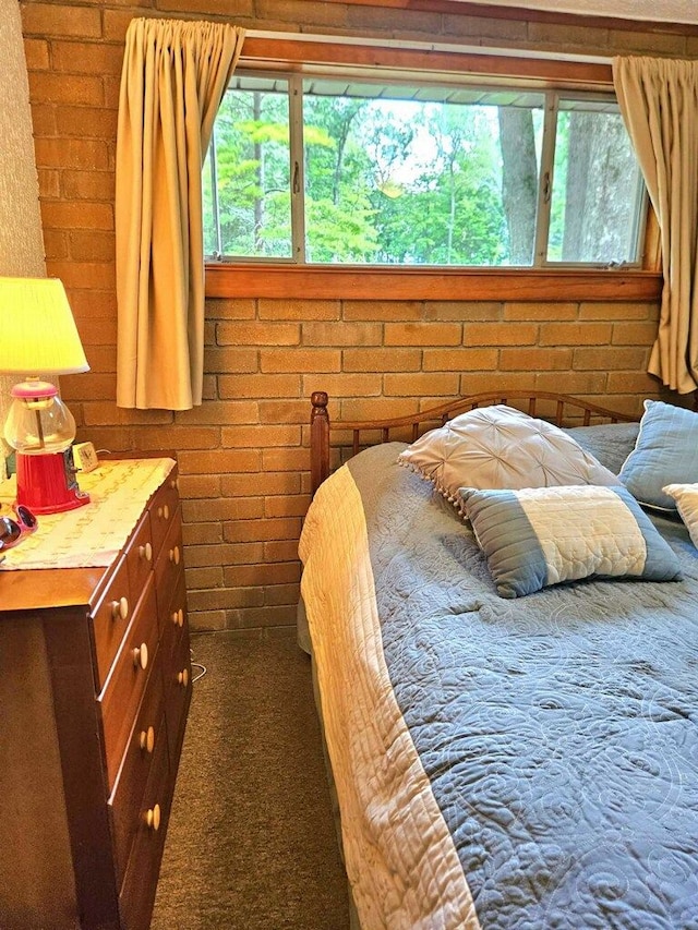 carpeted bedroom with brick wall