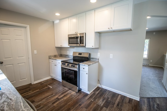 kitchen with light stone counters, white cabinets, stainless steel appliances, and dark hardwood / wood-style floors