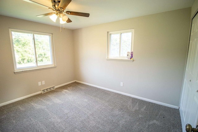 carpeted empty room with plenty of natural light and ceiling fan