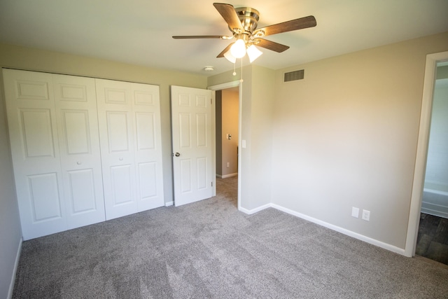 unfurnished bedroom featuring dark colored carpet, a closet, and ceiling fan