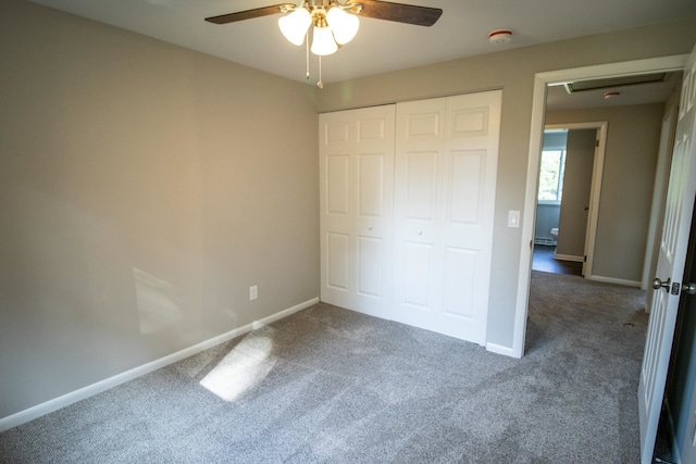 unfurnished bedroom with dark colored carpet, ceiling fan, and a closet